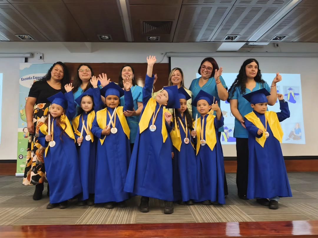 Graduación de Kínder con niños de toga azul y dorada